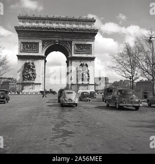 Anni '1950, auto storiche dell'epoca parcheggiate vicino al famoso arco trionfale, l'Arco di Trionfo a Place de l'etoile, Parigi, Francia. Foto Stock