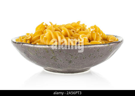 Sacco di tutto il marrone e secca fusilli integrali in scuro vaso in ceramica isolata su sfondo bianco Foto Stock