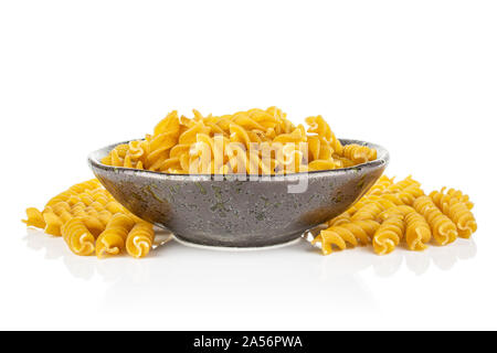 Sacco di tutto il marrone e secca fusilli integrali in scuro vaso in ceramica isolata su sfondo bianco Foto Stock