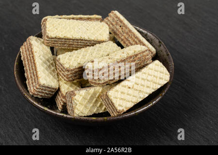 Sacco di tutta beige croccanti nocciole cookie di wafer in scuro vaso in ceramica in pietra grigia Foto Stock