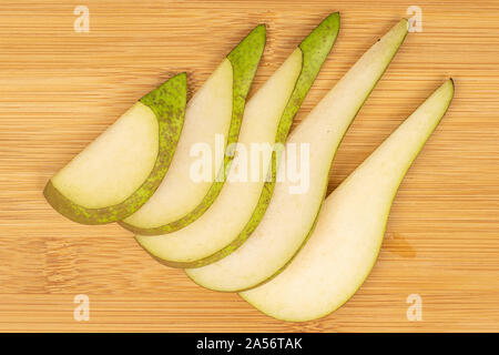 Il gruppo di cinque fette di fresco verde pera flatlay su legno chiaro Foto Stock