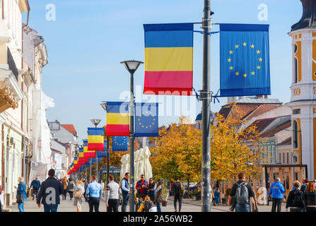 Linea di lanterne di strada con le bandiere della Unione europea e la Repubblica di Romania presso la Avenue Eroilor. Cluj-Napoca, Romania Foto Stock