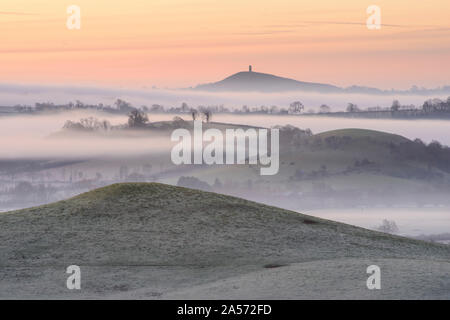 Misty Somerset campagna all'alba con Glastonbury Tor visibile all'orizzonte. Foto Stock