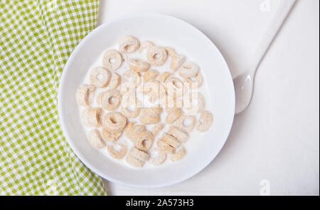 Deliziosi e nutrienti loop di cereali in una ciotola con il latte per la sana prima colazione per i bambini. Foto Stock