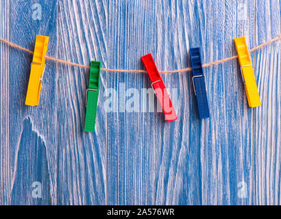 In plastica colorata clothespins blu su sfondo di legno Foto Stock