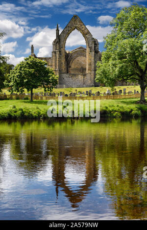 Xii secolo l agostiniano Bolton Priory rovine della Chiesa riflessa nel fiume Wharfe a Bolton Abbey Wharfedale North Yorkshire, Inghilterra Foto Stock
