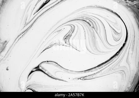 Sfondo astratto, vista dall'alto del bianco e del nero vernice roteato texture. Foto Stock