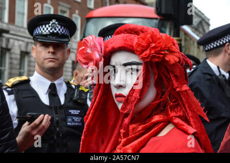 Londra, Regno Unito. Xviii oct, 2019. Gli attivisti spruzzata di rosso le mani sui dipartimenti governativi il venerdì a Londra che continuano la loro protesta per sollecitare il governo a intervenire sul clima di emergenza. Quasi 1.800 estinzione della ribellione manifestanti sono stati arrestati come di 2pm di oggi, la polizia ha detto, come il gruppo ha continuato la sua protesta a dispetto di un divieto di polizia. (Foto di Laura Chiesa/Pacific Stampa) Credito: Pacific Press Agency/Alamy Live News Foto Stock