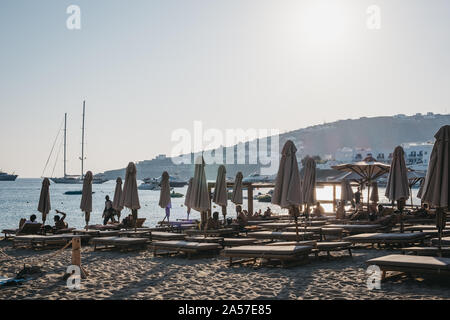 Mykonos, Grecia - 19 Settembre 2019: file di ombrelloni e lettini sulla spiaggia di Platis Gialos, una famosa spiaggia sulla costa sud di Mykonos. Messa a fuoco selettiva. Foto Stock
