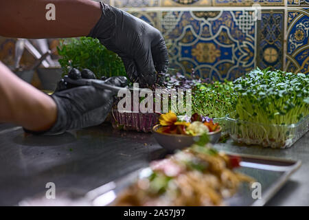 Concetto di cibo. Lo Chef taglia verdure fresche per piatti in un ristorante. Il processo per la fabbricazione di spaghetti con frutti di mare. Foto Stock