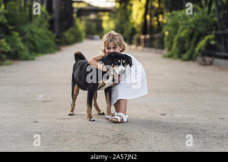 Felice giovane ragazza che abbraccia il suo sorriso pooch pet su Steele Canyon Bridge Foto Stock