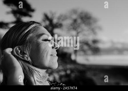 Ritratto di donna felice sotto il sole Foto Stock