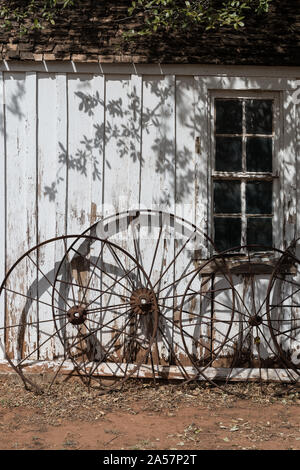 Ruote di carri contro un edificio a Buffalo Gap storico villaggio di Taylor non costituite in società County, Texas, città con lo stesso nome, nei pressi di Abilene Foto Stock