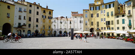 I turisti in una piazza cittadina, Piazza Dell'Anfiteatro, Lucca, Toscana, Italia Foto Stock