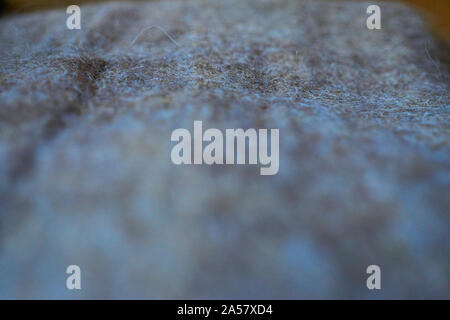 Close up della tessitura di grigio di una coperta di lana in luce calda Foto Stock