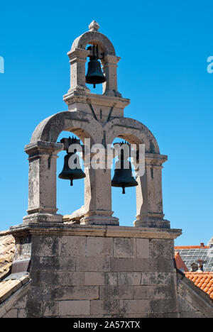 Chiesa Thuree campanelle dalla torre di una chiesa nella città vecchia di Dubrovnik, con colorati luminosamente tetti in background. Foto Stock