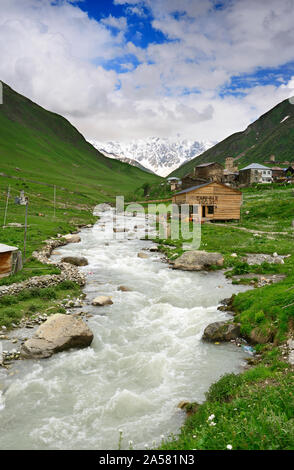 Il villaggio di montagna di Ushguli e il fiume Enguri con il picco Shkhara (5068 m) sullo sfondo. Un sito Patrimonio Mondiale dell'UNESCO. Svanetia superiore, G Foto Stock