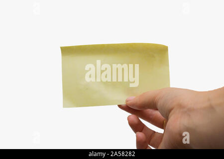 Donna che mantiene un vuoto bigliettino giallo isolato su sfondo bianco, spazio per il testo Foto Stock
