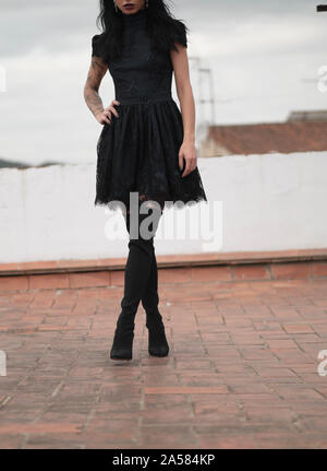 Tall slim donna che indossa abiti vintage e coscia-alti stivali Foto Stock