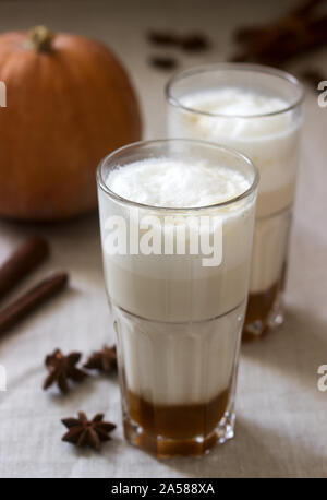 In casa la zucca latte in bicchieri alti e zucca su una tovaglia di lino. Stile rustico. Foto Stock