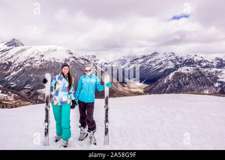 Due adulti, felice e donna sorridente su vacanze invernali in montagna innevata, sciatori con attrezzature da sci, Livigno, Italia, Alpi Foto Stock