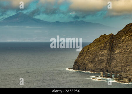 Vista dell'isola di Tenerife da Santa Catalina beach. Enormi pilastri di calcestruzzo per gru e le rovine della vecchia Hermigua porta. La Gomera Canarie, Isla Foto Stock