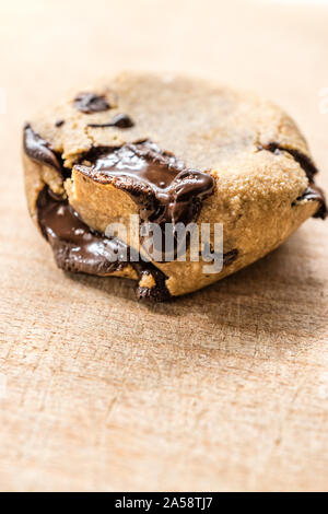 Paleo biscotti con scaglie di cioccolato fatto con le noci di cocco e farina di mandorle sulla tavola di legno. Organici di dessert con cioccolato fuso. Pronto a mangiare. Foto Stock