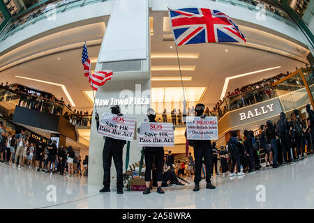 Hong Kong contestatori wave inglesi e americani le bandiere in segno di protesta in un centro commerciale per lo shopping di Hong Kong prima di violenza erutta Foto Stock