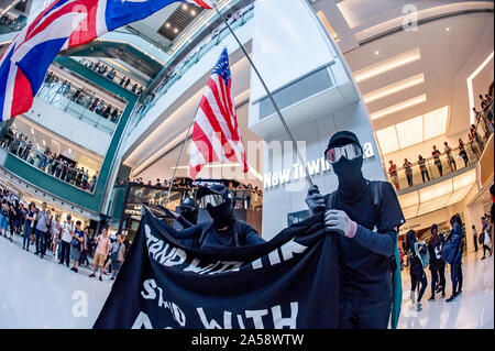 Hong Kong contestatori wave inglesi e americani le bandiere in segno di protesta in un centro commerciale per lo shopping di Hong Kong prima di violenza erutta Foto Stock