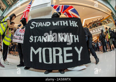 Hong Kong contestatori wave inglesi e americani le bandiere in segno di protesta in un centro commerciale per lo shopping di Hong Kong prima di violenza erutta Foto Stock