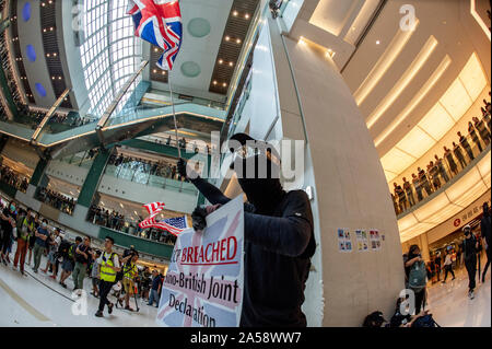 Hong Kong contestatori wave inglesi e americani le bandiere in segno di protesta in un centro commerciale per lo shopping di Hong Kong prima di violenza erutta Foto Stock