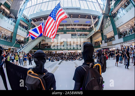 Hong Kong contestatori wave inglesi e americani le bandiere in segno di protesta in un centro commerciale per lo shopping di Hong Kong prima di violenza erutta Foto Stock