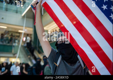 Hong Kong contestatori wave inglesi e americani le bandiere in segno di protesta in un centro commerciale per lo shopping di Hong Kong prima di violenza erutta Foto Stock