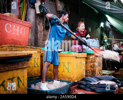 YANGON, MYANMAR - venditore ambulante in Yangon Mercato del Pesce la mattina presto. Foto Stock