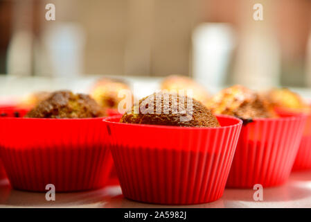 Pane appena sfornato tortine in silicone rosso tazze in cucina la luce solare Foto Stock