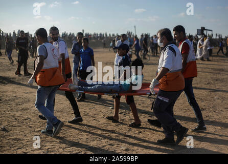 La striscia di Gaza, la Palestina. Xviii oct, 2019. I medici palestinesi trasportare una persona infortunata durante un anti-Israele dimostrazione per chiedere la fine di anni di assedio su Gaza sul confine Israel-Gaza nel sud della striscia di Gaza. Credito: SOPA Immagini limitata/Alamy Live News Foto Stock