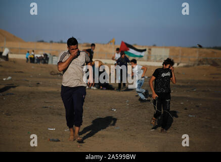 La striscia di Gaza, la Palestina. Xviii oct, 2019. Dimostranti palestinesi fuggono da le scatole metalliche del gas lacrimogeno sparato durante un anti-Israele dimostrazione per chiedere la fine di anni di assedio sul confine Israel-Gaza nel sud della striscia di Gaza. Credito: SOPA Immagini limitata/Alamy Live News Foto Stock