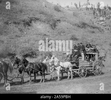 Vista laterale di a cavallo il stagecoach caricato con i passeggeri. Foto Stock