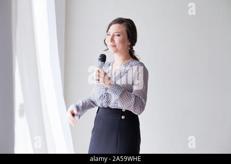 Donna asiatica parla in microfono canta bello Foto Stock