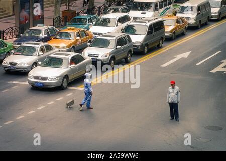 Shanghai, Cina - 19 ottobre 2006:spazzatrice e cop di traffico in una città frenetica intersezione Foto Stock