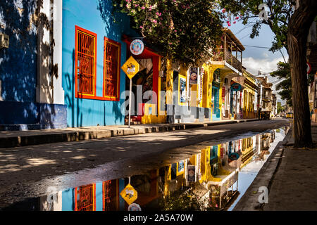 Gli edifici colorati si riflette in una grande pozza in una tranquilla strada laterale nel centro storico di Santa Marta in Colombia Foto Stock