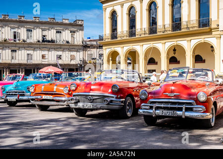 Scena di strada con Vintage Americano classico Taxi automobili in attesa per i turisti, Havana, Cuba Foto Stock