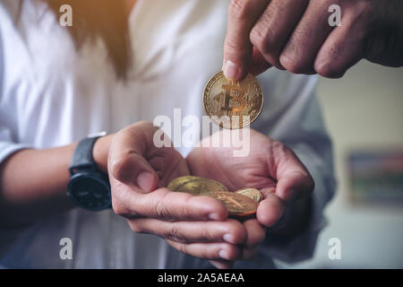 Primo piano immagine di persone dando e raccogliendo bitcoins Foto Stock