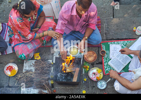 Un sacerdote al sacro Banganga serbatoio, Mumbai, India dirige un giovane nella conduzione di riti (shraddha) in ricordo del defunto rispetto Foto Stock