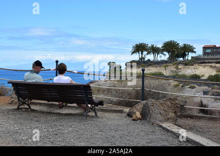 Giovane su un banco di lavoro, dal mare, Costa Adeje, Tenerife Foto Stock