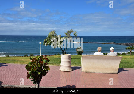 Giovane, seduti in riva al mare Costa Adeje, Tenerife Foto Stock