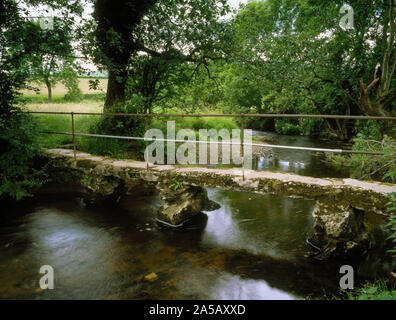 Llanarmon Yn Ial passerella sul fiume Alyn. Claper ponte di lunga e stretta di lastre di pietra supportato su pietra grezza e piloni in cemento con corrimano in ferro Foto Stock