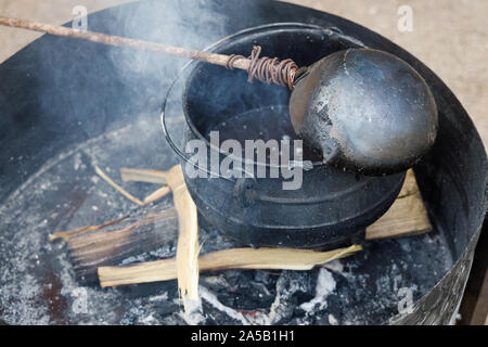 Pot nero in cui una cera viene fusa per produrre candele. Foto Stock