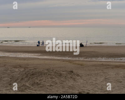 I pescatori nel crepuscolo della sera presso la spiaggia di Katwijk, Paesi Bassi. Foto Stock