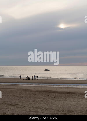 I pescatori nel crepuscolo della sera presso la spiaggia di Katwijk, Paesi Bassi. Foto Stock